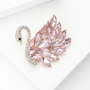 Detalle macro de broche de cisne dorado con cristales marquise rosas y micro pavé de diamantes