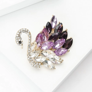 Detalle macro de broche de cisne con cristales púrpuras y base de aleación dorada