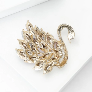 Detalle del reverso de un broche de cisne dorado con cierre de alfiler y cristales engastados
