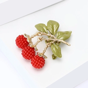 Close-up of enamel blackberry brooch featuring red berries and green leaves with gold stem