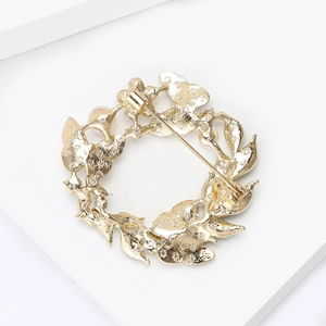 Élégante broche couronne à nœud doré avec perles et cristaux vue de dos avec l'épingle
