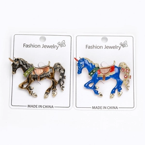 Dettagli delle spille unicorno in smalto blu e marrone con cristalli su cartoncino
