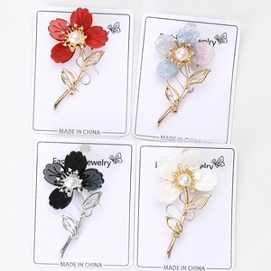 Détail de la broche fleur en résine avec perle centrale et petits cristaux brillants