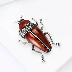 Vue détaillée de la broche scarabée en émail rouge avec accents de cristal brillant