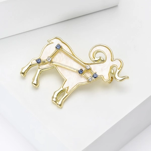 Detailed view of golden Aries constellation brooch with blue crystals and white enamel