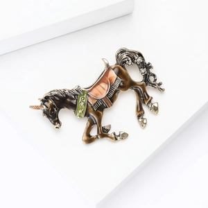 Dettaglio macro della spilla a forma di unicorno con finitura dorata e coda di cristalli