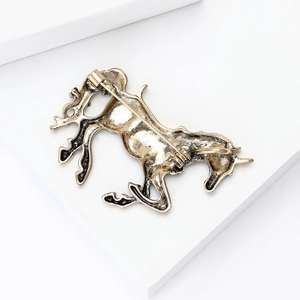 Dettaglio del retro di una spilla a forma di unicorno in oro antico con chiusura a spilla
