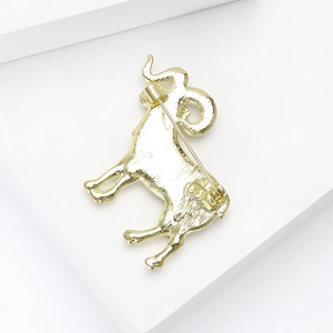 Minimalist golden Aries ram brooch with brushed metal finish and secure safety pin