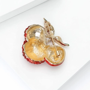 Cute cherry brooch with red rhinestones and green enamel on a golden metal base