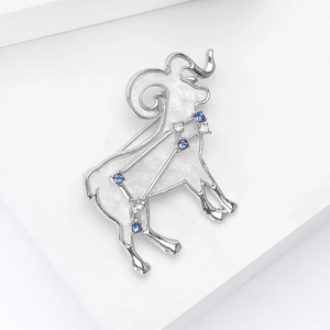 Detailed view of Aries ram brooch with white enamel, silver finish and blue crystals