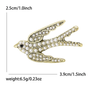 Broche hirondelle dorée en alliage avec perles blanches et strass noir brillant