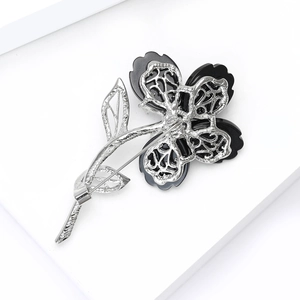 Vue arrière détaillée d'une broche fleurie montrant l'artisanat ajouré et le fermoir