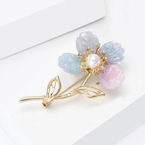 Détail d'élégante broche fleur à quatre pétales avec perle et strass étincelants