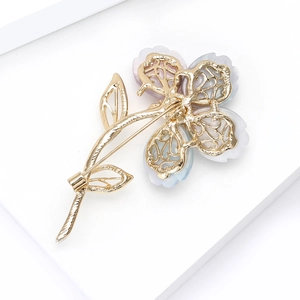Vue arrière détaillée d'une broche fleur à quatre pétales avec fermoir en métal doré