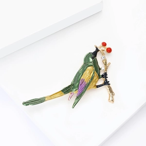 Prachtige ijsvogel broche in groen emaille met gouden tak en rode kralen decoratie