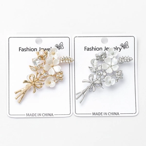 Vue détaillée des broches fleur de prunier en or et argent avec des strass en cristal
