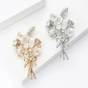 Élégante broche bouquet de fleurs de prunier avec pétales blancs, perles et cristaux or et argent
