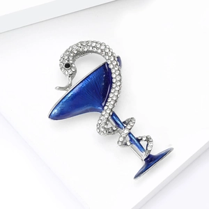 Détail macro de la broche serpent avec strass et verre à cocktail en émail bleu foncé