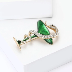 Détail d'une broche serpent et coupe en émail avec strass blancs sur alliage doré