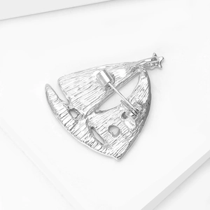 Detailed back view of silver sailboat brooch featuring a secure pin clasp mechanism