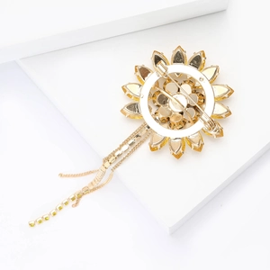 Detail of sunflower brooch back with golden pin and long rhinestone tassels on white base