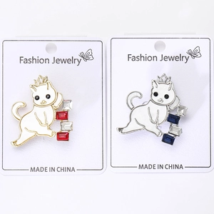 Detail view of gold and silver cat brooches with colorful rhinestones on card