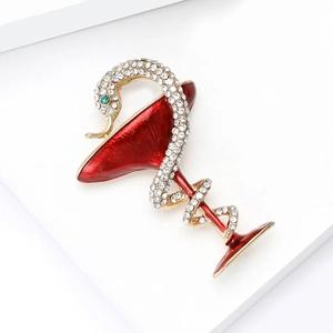 Détail de la broche serpent en émail avec strass entourant un verre à cocktail