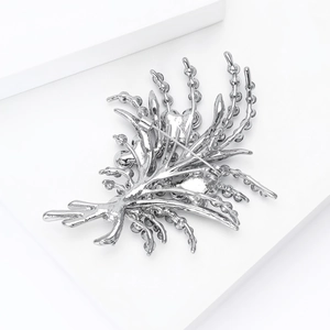 Broche bouquet en alliage argenté avec strass brillants sur présentoir géométrique