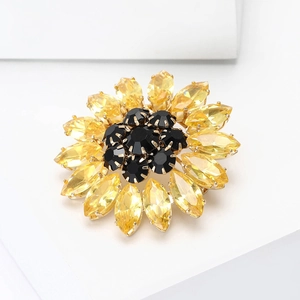 Detailed macro view of crystal sunflower brooch with yellow petals and black gem center