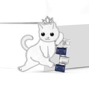 Elegant white cat brooch with silver crown and blue crystals on minimalist background