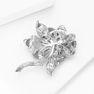 Detailed back view of a silver rose brooch with intricate hollow texture and pin fastener
