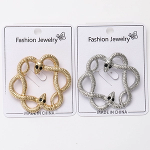 Detailed view of gold and silver snake-shaped brooches with fine scale texture and black rhinestones