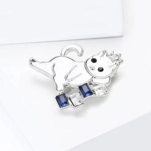 Detail of cute cat brooch featuring white enamel finish and sparkling blue crystal accents