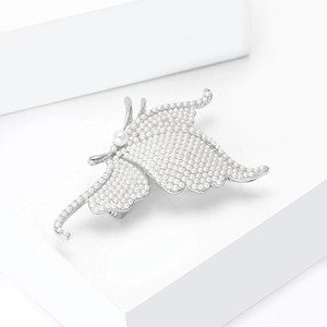 Macro detail of elegant silver butterfly brooch with intricate white pearl inlay