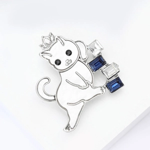 Detail of silver cat brooch with crown and blue rectangular crystal stones inlay