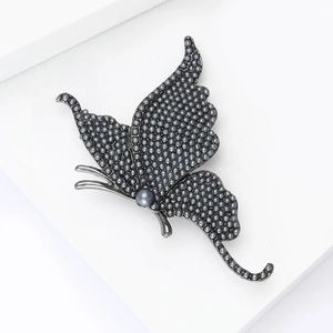 Detailed close-up of grey pearls pave setting on a butterfly brooch with gunmetal finish