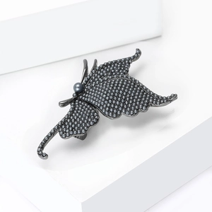 Detailed view of gunmetal butterfly brooch with textured bead wings and grey pearl center
