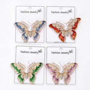 Lot de quatre broches papillon avec émail, perles et strass sur cartes de bijoux