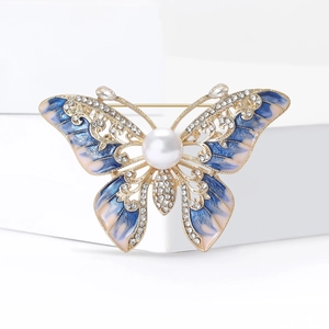 Élégante broche papillon dorée avec des ailes en émail et cristaux de strass