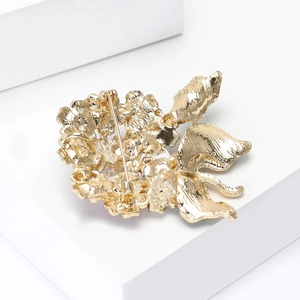 Detailed back view of the gold floral brooch showing the pin clasp and metal texture