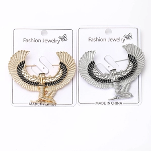 Detailed close-up of gold and silver Egyptian Isis goddess brooches with enamel wings