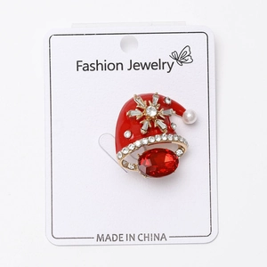 Détail de la broche bonnet de Noël en émail rouge avec strass flocon et gemme rouge