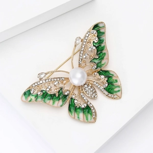 Vue détaillée de la broche papillon en émail avec cristaux et grande perle