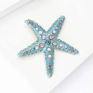 Gros plan détaillé d'une broche étoile de mer avec strass colorés et bords dorés