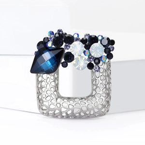 Hollow square alloy brooch with midnight blue rhinestones on a minimalist white stand