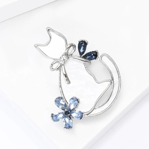 Macro view of silver cat brooch with blue crystal flowers and sparkling rhinestones