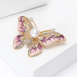 Vue détaillée de la broche papillon en émail violet avec cristaux et une grande perle blanche