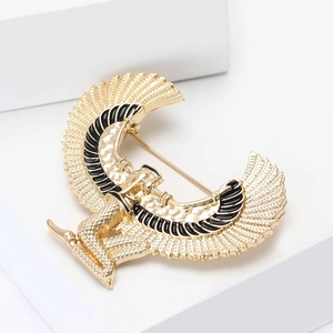 Golden Egyptian goddess wing brooch with detailed feather texture and black enamel accents
