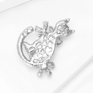 Detail of silver cat brooch back featuring heart-shaped cutouts and pin fastener