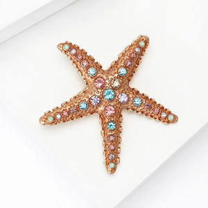 Vue détaillée d'une broche étoile de mer en alliage avec strass colorés et base or rose